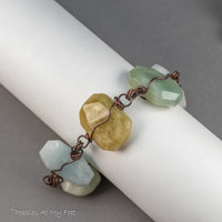 A Handmade Aquamarine Stone Bracelet Shown on a Form as if Being Worn on a Wrist