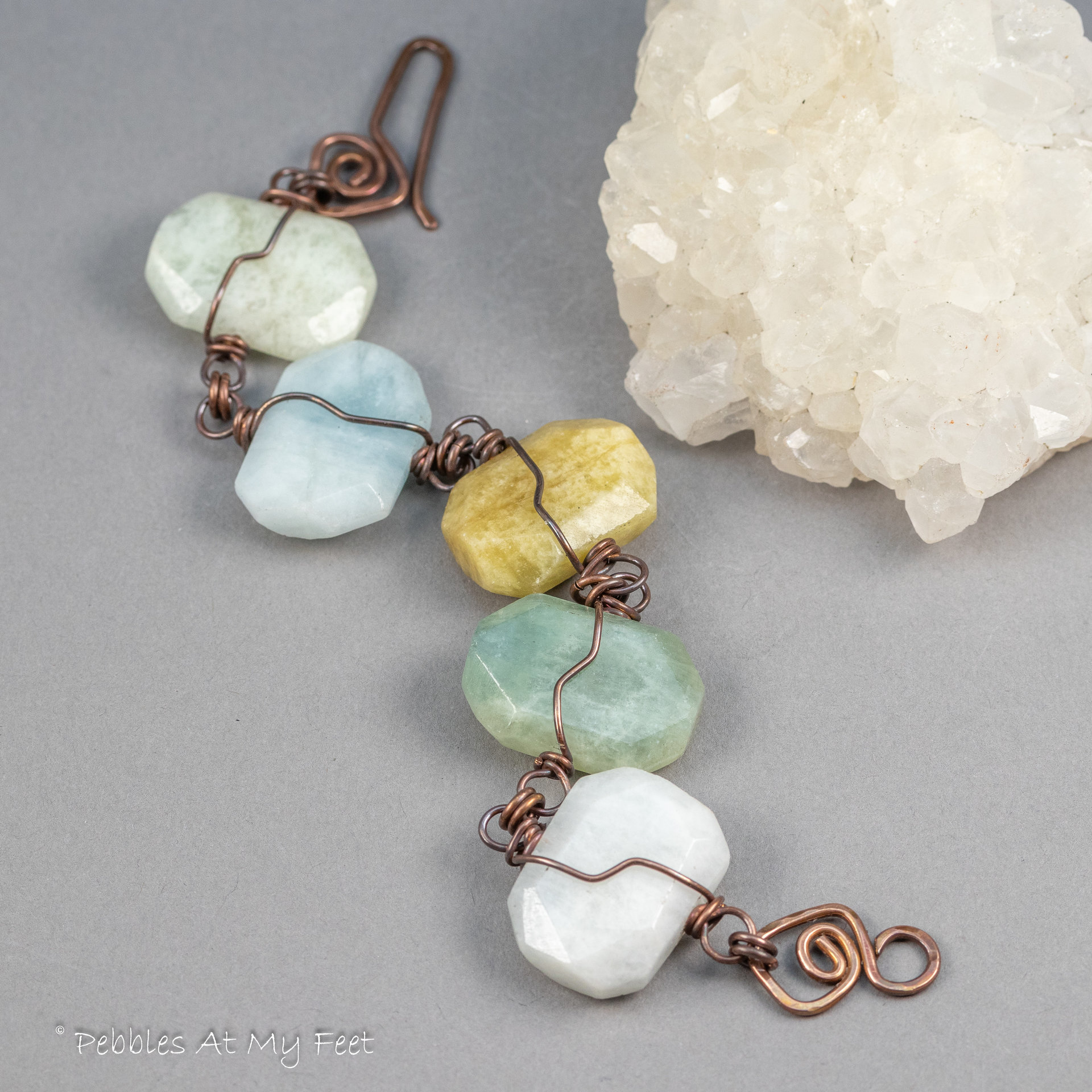 A Handcrafted Bracelet Laid out to Display its Five Different Color Aquamarine Stones 